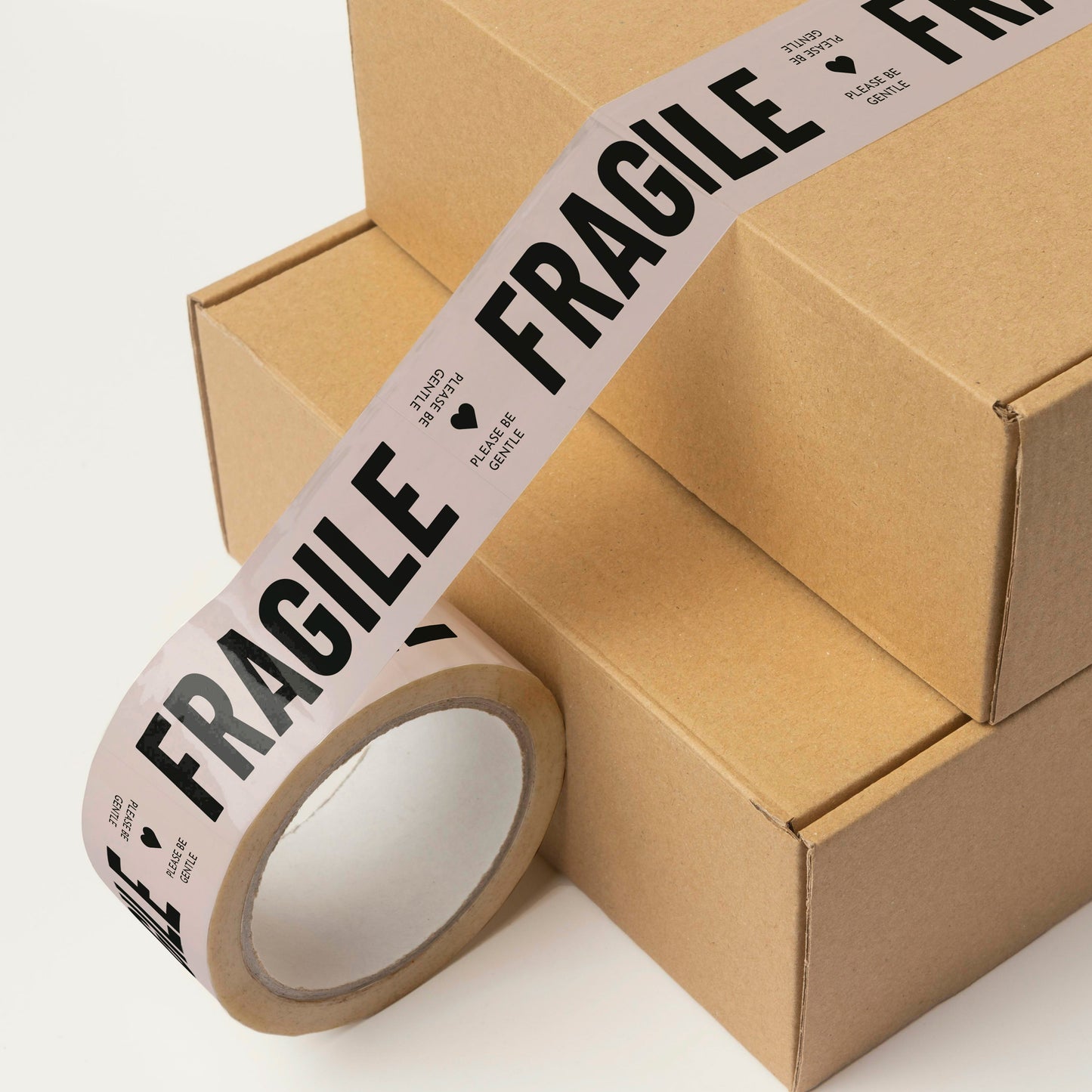 Boxes of ceramics ready for shipping, secured with high-quality cream and black tape that reads 'Fragile, Please Be Gentle'.