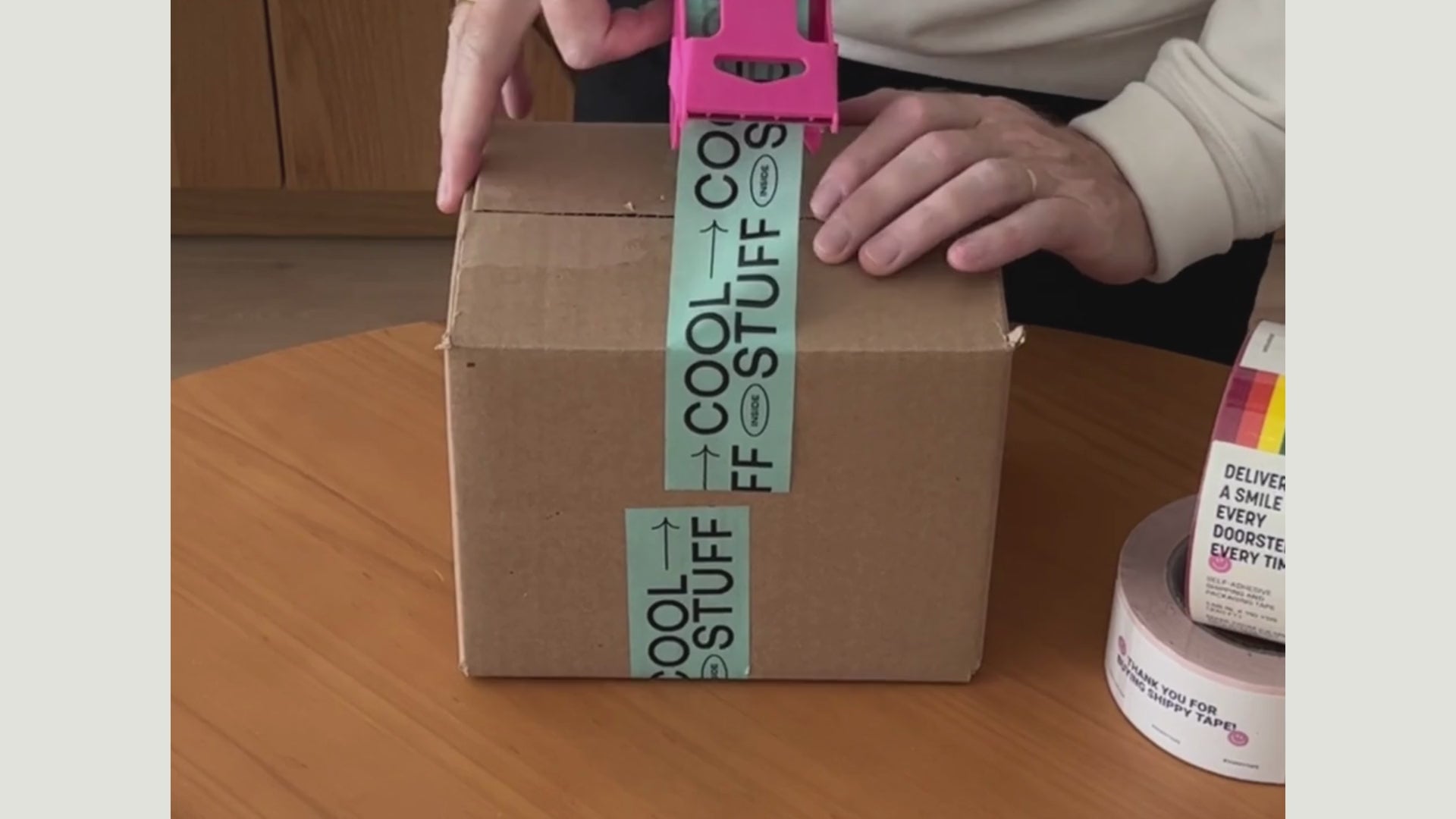 Video of man taping a moving box with colorful packaging tape for small businesses.