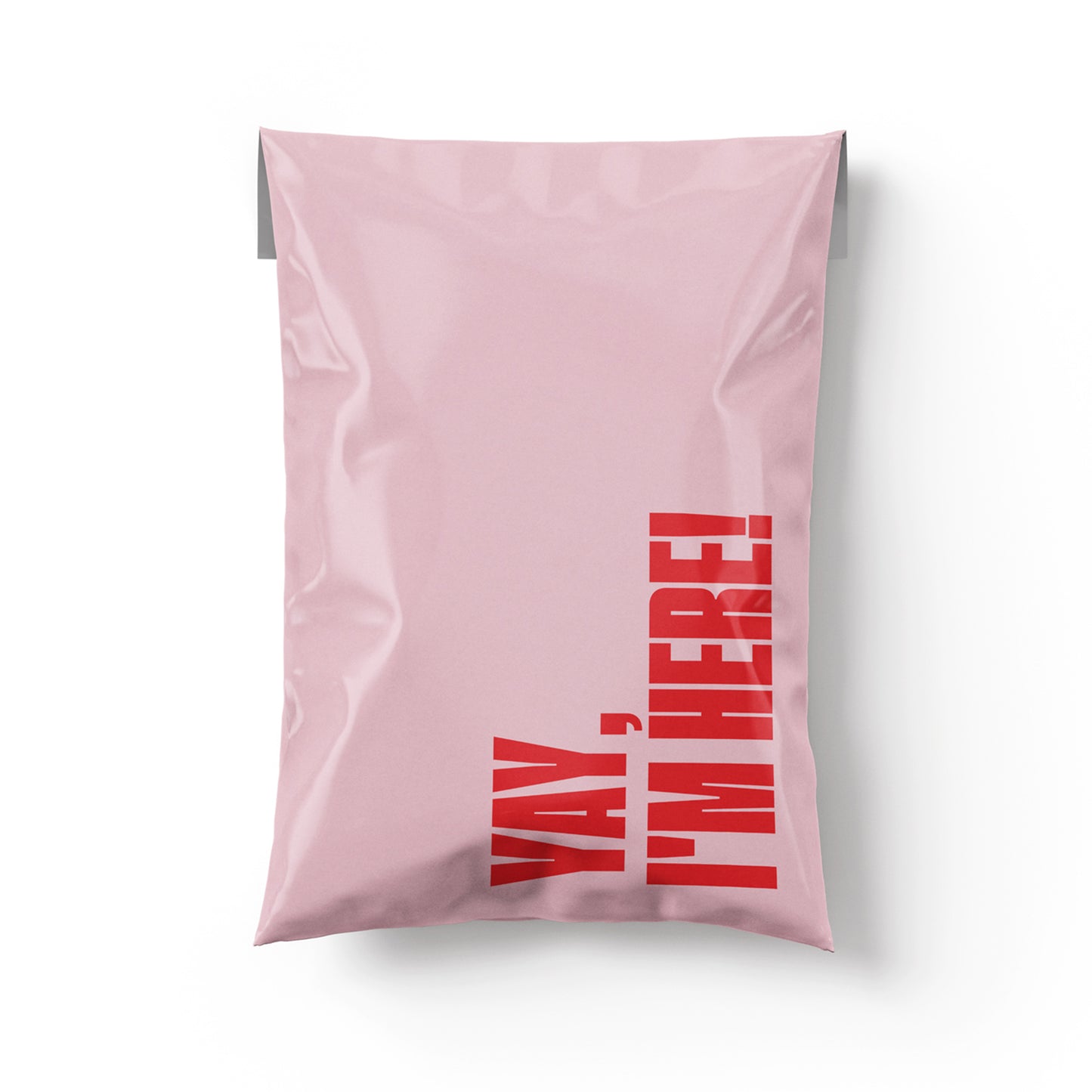 Pink pillow with red text 'Yay, I'm here!' on a white background