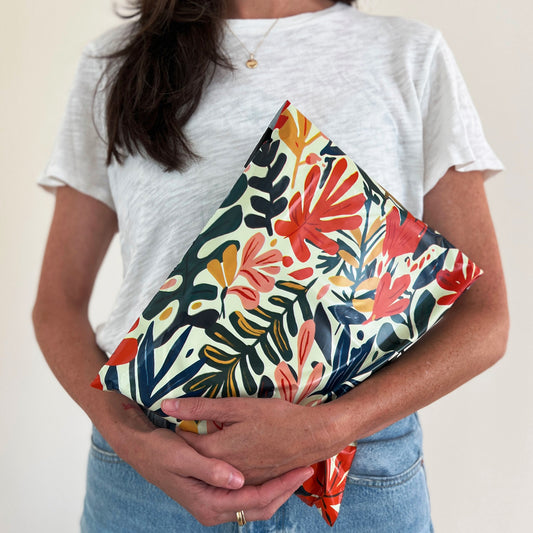 Person holding a Cute tropical floral-patterned poly mailer for Poshmark shipping.