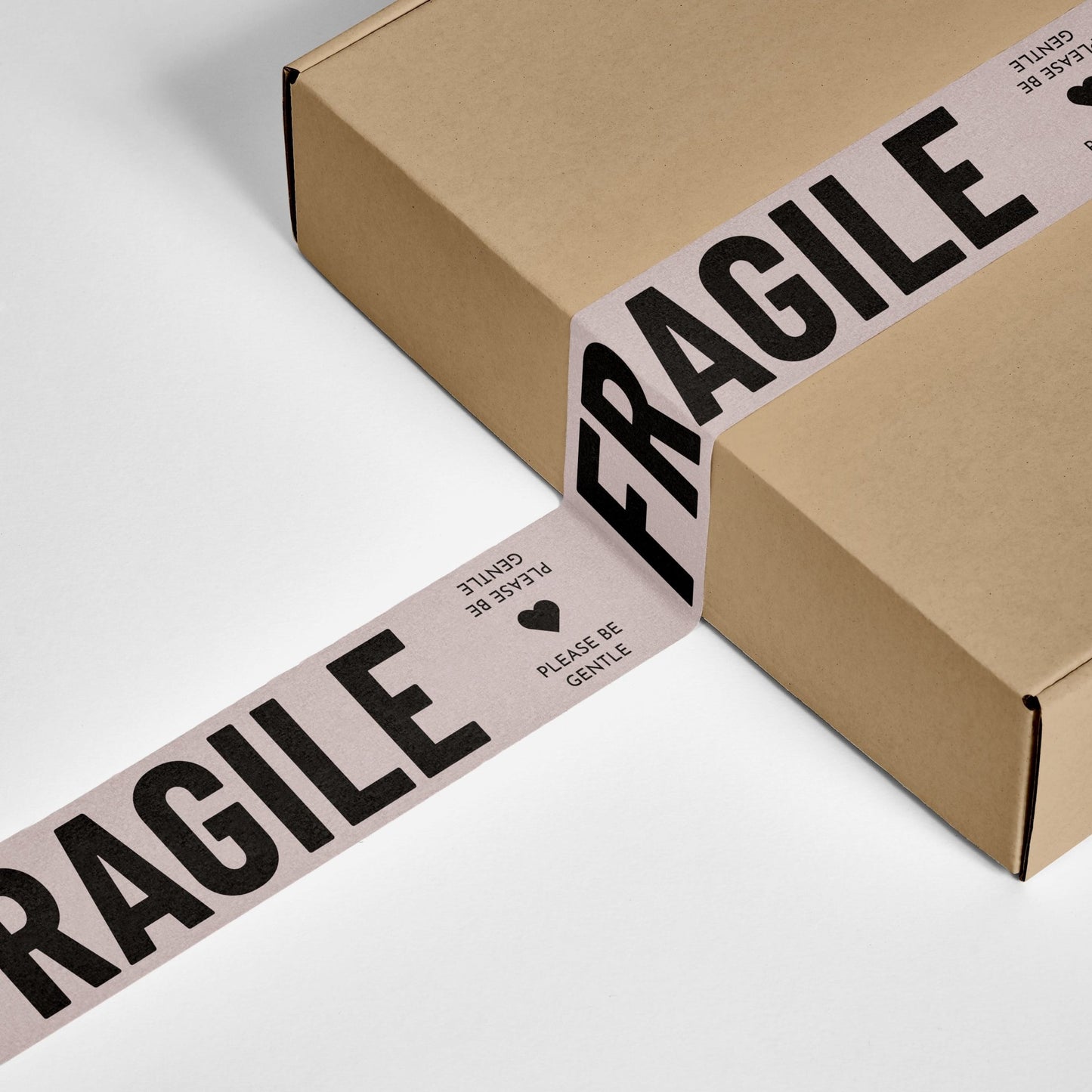 Cream and black 'Fragile, Please Be Gentle' printed shipping tape on a securely sealed box.