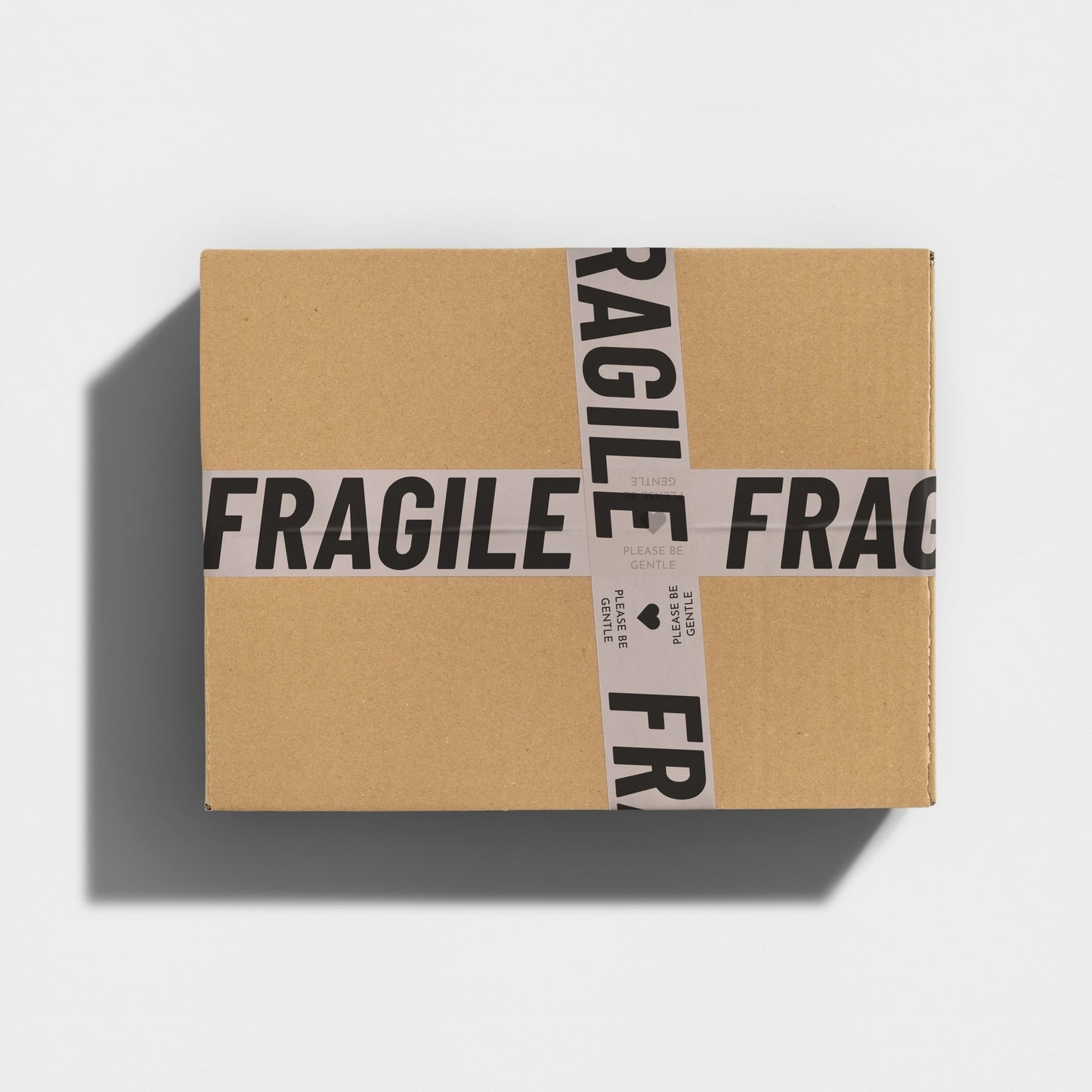 Securely sealed shipping box, with eye-catching cream and black tape stating 'Fragile, Please Be Gentle' in bold font.