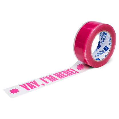 A roll of clear packing tape with Yay I'm Here in pink printed on it.